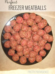 a black plate filled with meatballs on top of a table