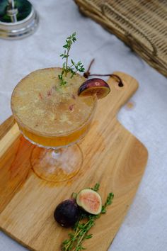 a drink sitting on top of a wooden cutting board