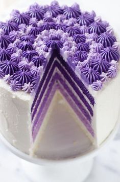 a cake with purple frosting is shown on a plate