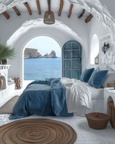 a bedroom with an arched doorway leading to the ocean and a bed that has blue sheets on it