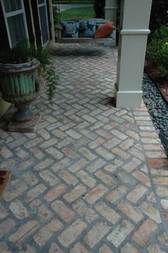 a brick walkway leading to a covered patio