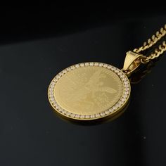 Mit der Iced Bezel Centenario-Halskette verleihen Sie sich einen opulenten Stil mit viel Bedeutung. Dieses Stück symbolisiert Erfolg und verwirklichte Träume und feiert diejenigen, die aus bescheidenen Verhältnissen ein erfolgreiches Leben geführt haben. Es inspiriert dazu, nach mehr zu streben. Schmücken Sie sich mit einer luxuriösen Erinnerung an hart erkämpften Erfolg und grenzenloses Potenzial.
 Kettenlänge: 24"
 Anhängergröße: 1,77" x 1,57"
 Gewicht: 41,6 g
 Vergoldet