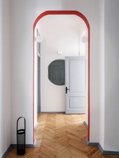 an empty room with a white door and red trim