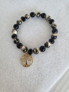 Black and white beads with gold tone accents and charm threaded with a durable  elastic cord. Golden Bracelet, Bracelets Ideas, Golden Beads, Gold Jewelry Simple Necklace, Resin Bracelet, Jewelry Simple, Gold Jewelry Simple, Black Thread, Plastic Resin