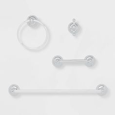 three pairs of bathroom accessories including two towel bars, one ring and the other round