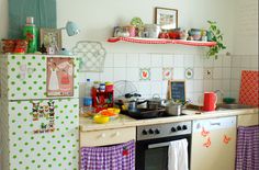 the kitchen is decorated with colorful polka dot curtains and pots, pans, and utensils