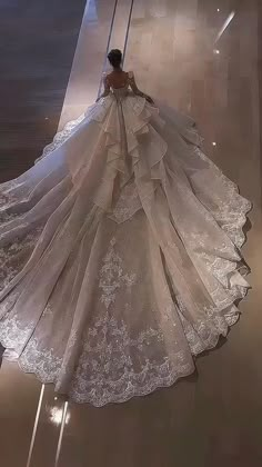 a woman in a wedding dress is walking down the runway