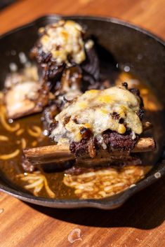 a skillet filled with food on top of a wooden table