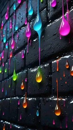 colorful drops of water hanging from the side of a brick wall