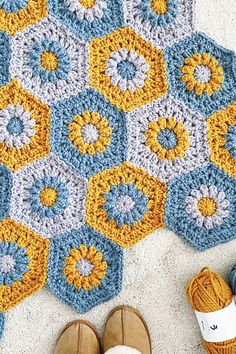 a crocheted rug with yellow, blue and white hexagons on it