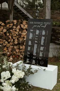 there is a sign that says our favorite people on it next to flowers and logs