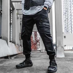 A stylish clothing that is hip hop and punk. It is fashionable, stylish, and it will look great on anyone who wears it. Do you wanahavit? Black Cargo Jeans For Outdoor Activities, Combat Parachute Pants With Multiple Pockets, Black Techwear Bottoms For Outdoor Activities, Black Pants With Functional Pockets For Outdoor Activities, Black Cargo Jeans With Pockets For Outdoor, Black Punk Pants For Winter, Techwear Cargo Parachute Pants, Techwear Parachute Pants With Side Pockets, Outdoor Techwear Cargo Pants