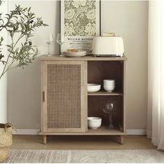 a wooden cabinet sitting next to a window with a vase and glass on top of it