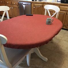 a red table with two white chairs around it