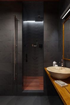 a bathroom with a wooden counter top next to a walk in shower