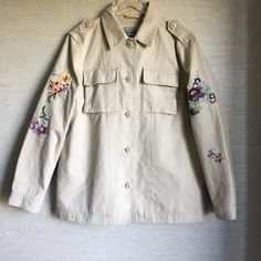 A Floral Embroidered Jacket Is The Next Addition To Your Outerwear Collection With Multiple Pockets And Front Button Closure. - Point Collar - Front Button Closure - Long Sleeves With Floral Embroidery Details - 2 Front Chest Flap Pockets - 2 Side Pockets - Solid - Approx. 28" Length 100% Cotton Machine Wash Cold Nwot Fall Beige Outerwear With Floral Embroidery, Beige Floral Embroidered Outerwear For Fall, Casual Cotton Outerwear With Embroidered Cuffs, Casual Fall Outerwear With Embroidered Cuffs, Casual Outerwear With Embroidered Cuffs For Fall, Floral Embroidery Long Sleeve Workwear Outerwear, Floral Embroidered Long Sleeve Workwear Outerwear, Floral Embroidery Long Sleeve Outerwear For Work, Long Sleeve Embroidered Outerwear With Pockets