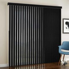 a blue chair sitting in front of a window with black slats on the sliding door