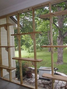 the inside of a house that is being built with wooden shelves and wire mesh around it