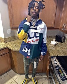 a man with dreadlocks standing in a kitchen