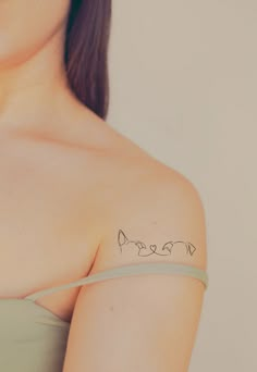 a woman with a tattoo on her shoulder that has three fish drawn on the chest