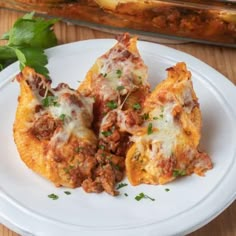 three pieces of pizza on a white plate with parsley sprinkled around the edges