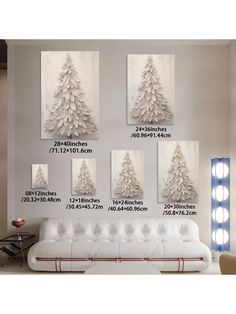 four white christmas trees are hanging on the wall above a couch in front of a mirror