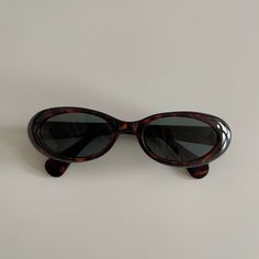 These round oval sunglasses are your everyday classic frames.  Featuring a brown tortoise frame with a smoke lens.  This style is unisex.  True genuine vintage sunglasses from the 90s.   - 400 uv  - new vintage from the 90s -Material: polyurethane frame , steel arms embedded within frame and glass lens Measurements:  Frame width: 147mm Lens Height: 30mm  Lens Width: 51mm  Bridge: 17mm  Arm temple: 140mm - includes sunglasses pouch also available in black 90s Sunglasses Aesthetic, 90s Sunglasses Vintage, Vintage Shoes Aesthetic, Oval Sunglasses 90s, Sunglasses Round Face, Vintage Wishlist, Vintage Round Sunglasses, 90s Accessories, Glasses Inspo