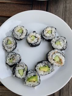 sushi is arranged in the shape of a heart on a white plate