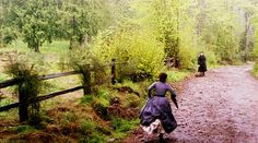 two people walking down a path in the woods