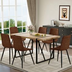 a dining room table with brown chairs and a white rug on the floor in front of a window