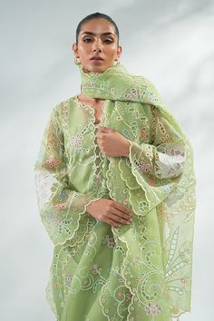 "A timeless organza shirt and dupatta are rendered with a playful fusion of cutwork and signature SM floral embroidery in pastel shades over a lemon green base. Rawsilk trousers with scalloped edges and tassel detailing complement the look.                                      Model Specifications:Model height: 5'10Len Elegant Spring Dupatta With Chikankari Embroidery, Spring Kurta With Sheer Dupatta In Organza, Spring Organza Kurta With Chikankari Embroidery, Elegant Salwar Kameez With Cutwork For Spring, Organza Salwar Kameez For Spring Wedding, Elegant Spring Sharara With Dupatta, Pista Green Lawn Suit For Summer Wedding, Spring Party Palazzo Set With Sheer Dupatta, Pista Green Dupatta For Summer Weddings