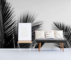 black and white palm tree wallpaper in a living room with two chairs next to it