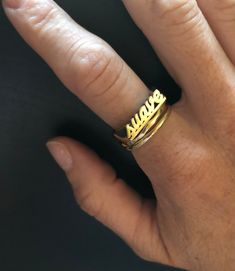 "Have a little fun and take your bling to another level with the Suave word ring. Stack it with other smaller rings. Pair it with other word rings like this one: https://www.etsy.com/listing/1063378702/rico-word-ring-rico-rich-word-ring?ref=shop_home_active_1&frs=1 word length: 16mm word height: 3 mm word width: 4 mm shank width: 1.5 mm This ring can be cast in brass, silver, or 14k gold plated over silver. If you are interested in solid gold please message me and we can discuss pricing. Love it Custom Name Adjustable Open Ring, Classic Gold Rings With Names, Elegant Named Jewelry For Promise, Classic Name Ring Jewelry, Adjustable Gold Engraved Couple Rings, Custom Name Yellow Gold Jewelry For Promise, Customizable Gold Stackable Promise Rings, Gold Engraved Names Ring For Wedding, Adjustable Stackable Promise Rings With Custom Name