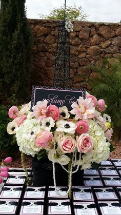 a table topped with pink and white flowers next to a eiffel tower sign