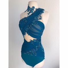 a mannequin wearing a blue one piece swimsuit with sequins on it