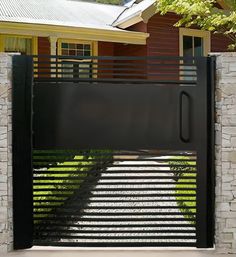 a black gate is open on the side of a house