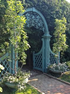 an arch in the middle of a garden with potted plants