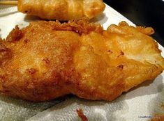 two fried food items sitting on top of a piece of paper with chopsticks