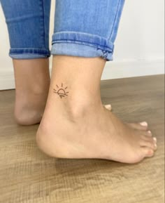 a woman's foot with a small sun tattoo on her left ankle and right leg