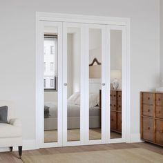 a living room with white furniture and mirrored doors