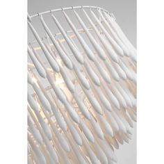 the light fixture is made out of white plastic and has long, curved rods hanging from it