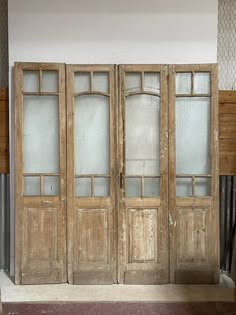 an old wooden double door with glass panels