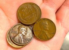 three coins are shown in the palm of someone's hand, which is holding them