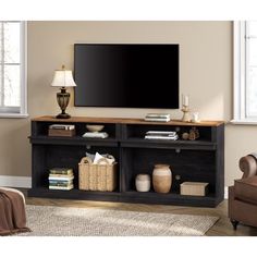 a living room with a large flat screen tv on top of a wooden entertainment center