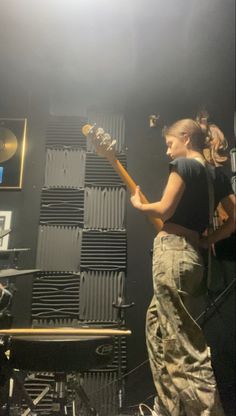 a woman standing in front of a guitar on stage