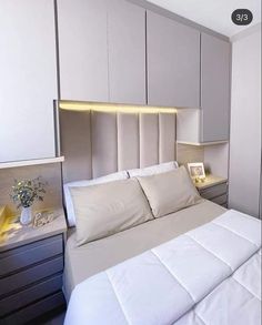 a bed with white sheets and pillows in a room