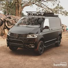 a black van parked in front of a tree with its roof rack on it's flatbed