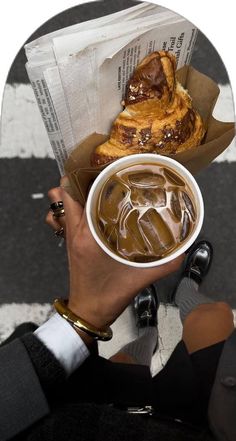 a person holding a cup of coffee and some pastries