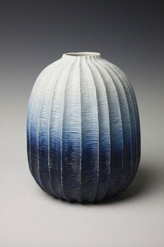 a white and blue vase sitting on top of a table