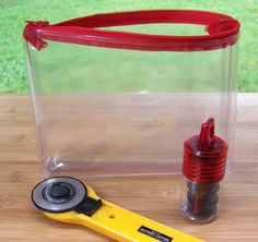 a pair of scissors sitting on top of a wooden table next to a plastic container